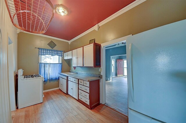 kitchen with light hardwood / wood-style floors, white cabinets, sink, ornamental molding, and white appliances