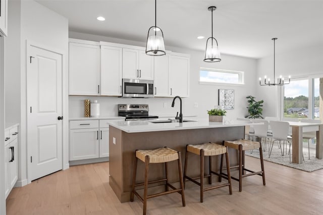 1930 Bowstring Dr, Marion, IA 52302 - kitchen featuring stainless steel appliances, light wood finished floors, healthy amount of natural light, a breakfast bar area, and recessed lighting