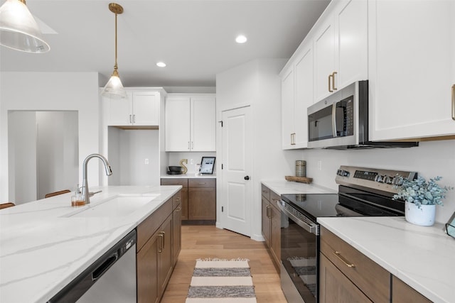 1932 Bowstring Dr, Marion, IA 52302 - kitchen featuring stainless steel appliances, a sink, light wood-style flooring, white cabinetry, and light stone countertops