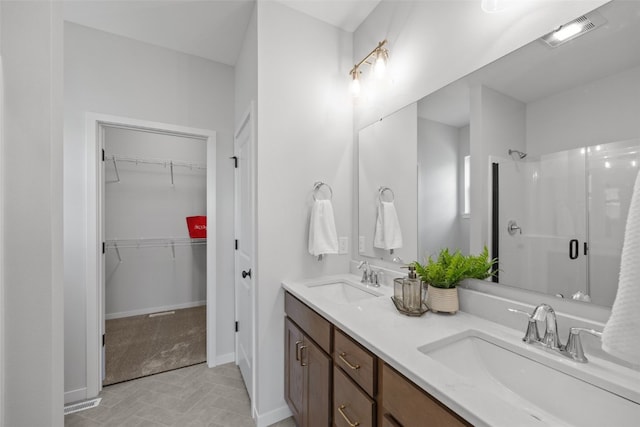 1932 Bowstring Dr, Marion, IA 52302 - full bathroom with a shower stall, double vanity, a walk in closet, and baseboards
