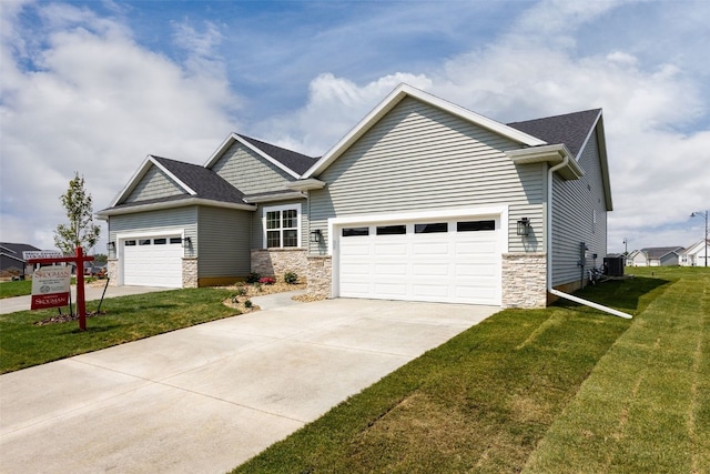 1932 Bowstring Dr, Marion, IA 52302 - craftsman-style house featuring stone siding, concrete driveway, a garage, and a front yard