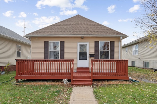 back of house featuring a wooden deck and a yard