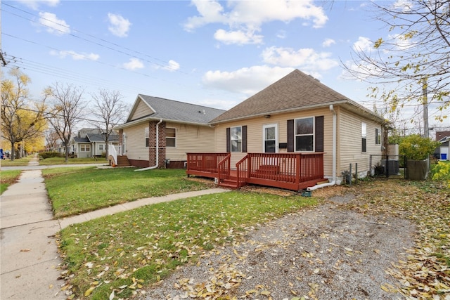 bungalow-style home with a front yard and a deck