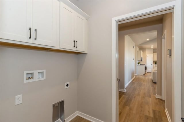 clothes washing area featuring cabinets, hookup for a washing machine, light wood-type flooring, and electric dryer hookup