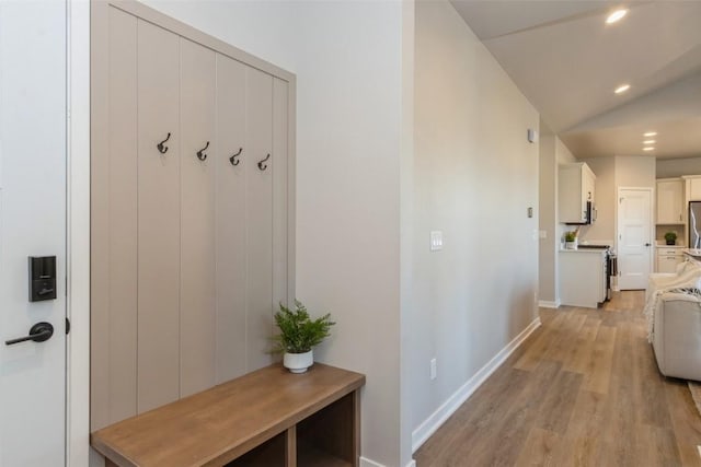 mudroom featuring vaulted ceiling and light hardwood / wood-style flooring