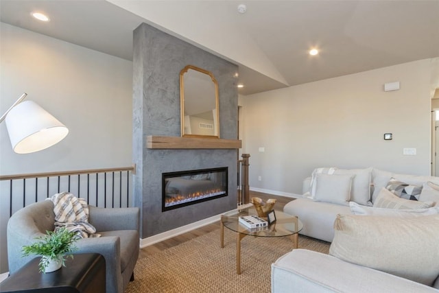 living room with a fireplace, hardwood / wood-style floors, and vaulted ceiling