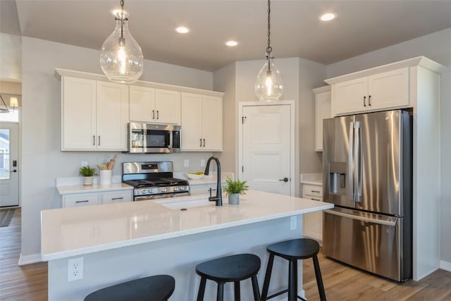 kitchen featuring stainless steel appliances, white cabinetry, and sink