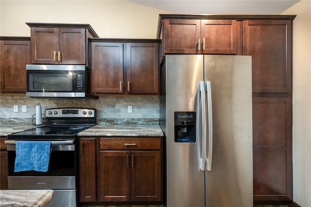 kitchen featuring dark brown cabinetry, appliances with stainless steel finishes, light stone counters, and backsplash