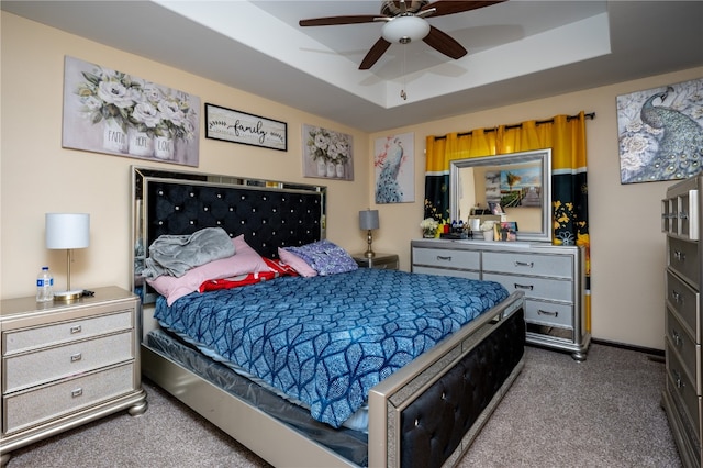 bedroom with carpet flooring, ceiling fan, and a raised ceiling