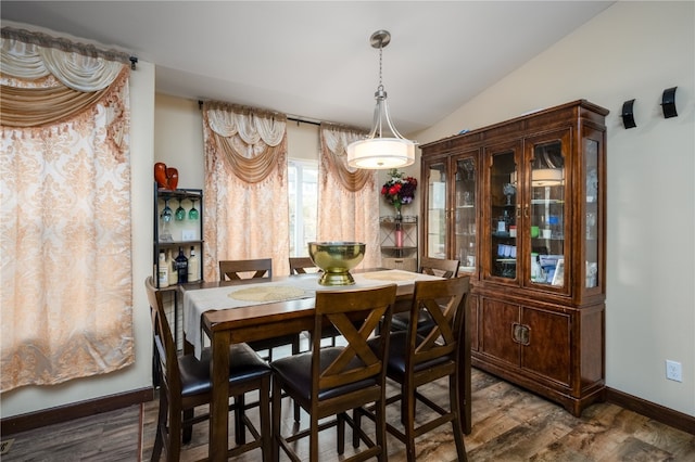 dining space with lofted ceiling and dark hardwood / wood-style floors