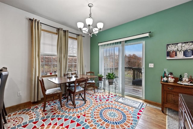 dining space featuring a notable chandelier and light hardwood / wood-style flooring