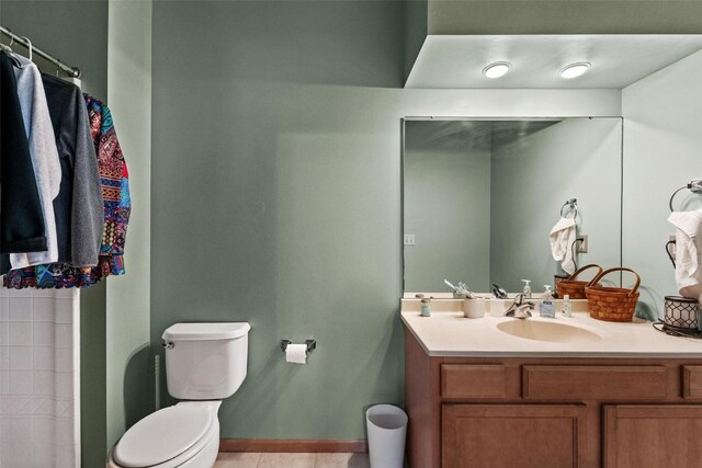 bathroom with tile patterned flooring, vanity, and toilet