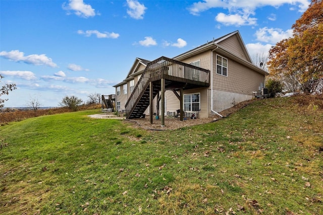 back of house featuring a wooden deck and a lawn