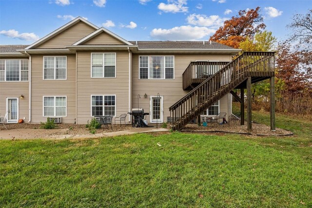 back of property featuring a wooden deck and a yard