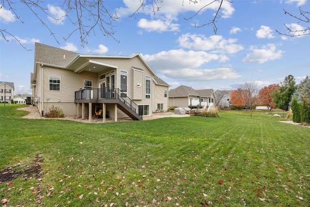 back of house with a deck, a yard, and a patio