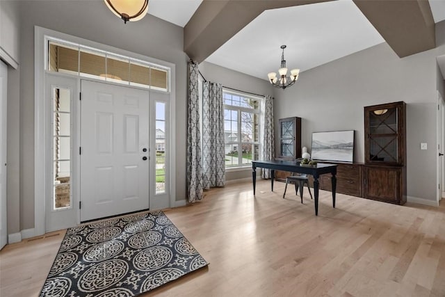 foyer with light hardwood / wood-style floors and an inviting chandelier