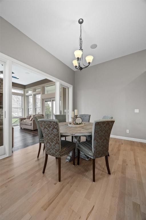 dining space featuring light wood-type flooring and a notable chandelier