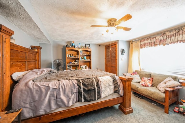 carpeted bedroom with ceiling fan, a textured ceiling, and a closet