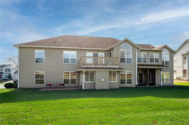 back of property with a patio area, a lawn, and a balcony