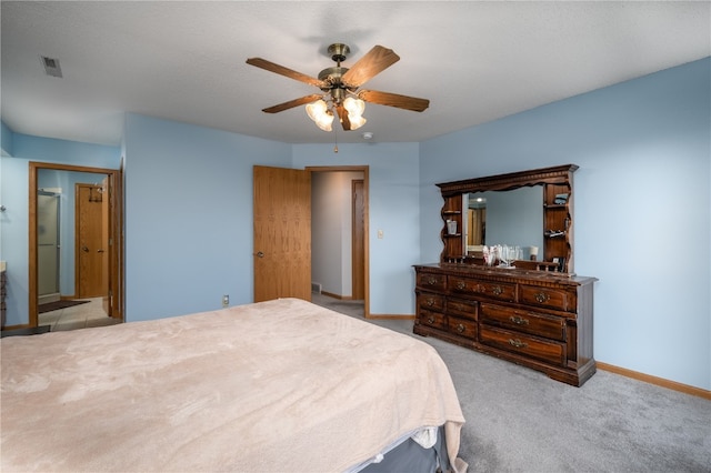 bedroom featuring ceiling fan, connected bathroom, and light carpet