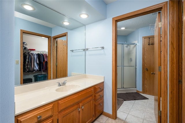 bathroom featuring walk in shower, vanity, and tile patterned floors