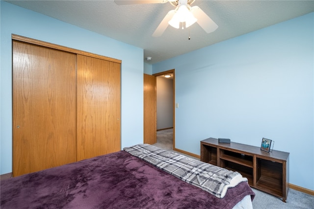 bedroom with a textured ceiling, light carpet, ceiling fan, and a closet