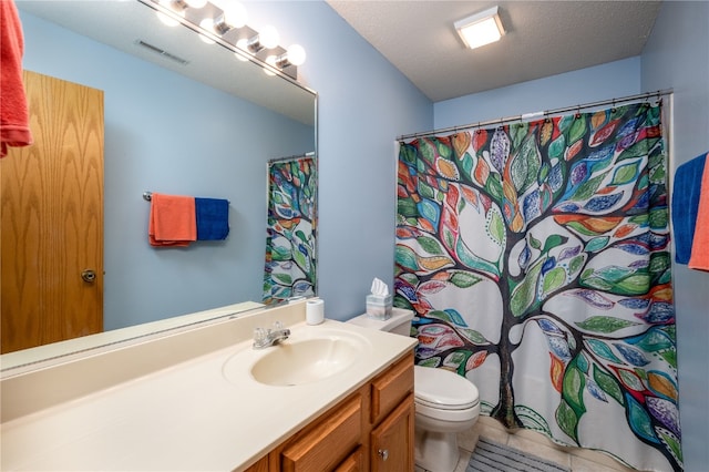 bathroom featuring toilet, vanity, a textured ceiling, and tile patterned floors