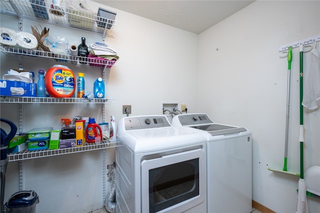 clothes washing area with a textured ceiling and separate washer and dryer