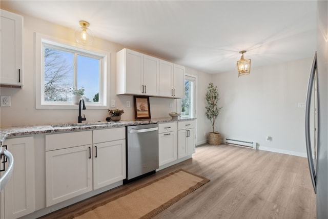 kitchen featuring stainless steel appliances, baseboard heating, white cabinetry, and plenty of natural light