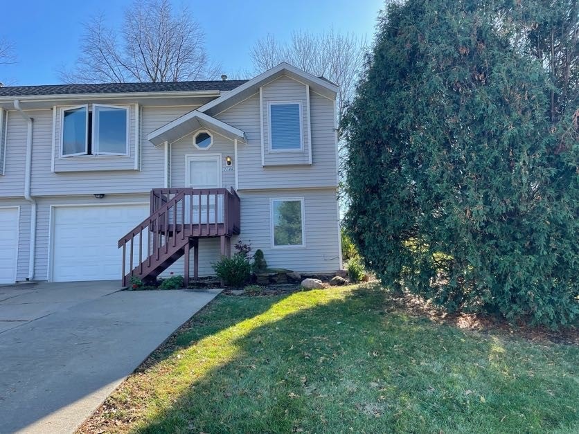 raised ranch with a front lawn and a garage