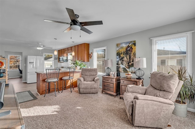 carpeted living room with ceiling fan and bar