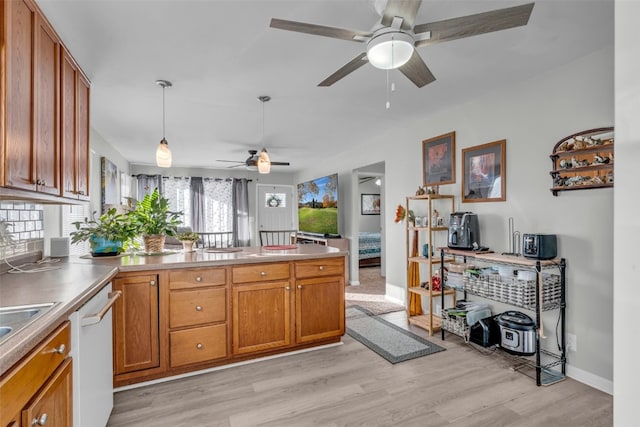 kitchen with light hardwood / wood-style floors, decorative light fixtures, ceiling fan, and white dishwasher