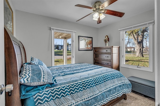 carpeted bedroom featuring ceiling fan and multiple windows