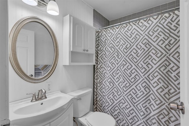 bathroom featuring toilet, vanity, and curtained shower