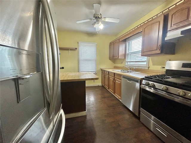 kitchen featuring appliances with stainless steel finishes, dark hardwood / wood-style floors, sink, and ceiling fan