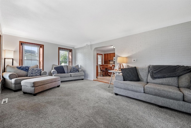 living room with brick wall and carpet