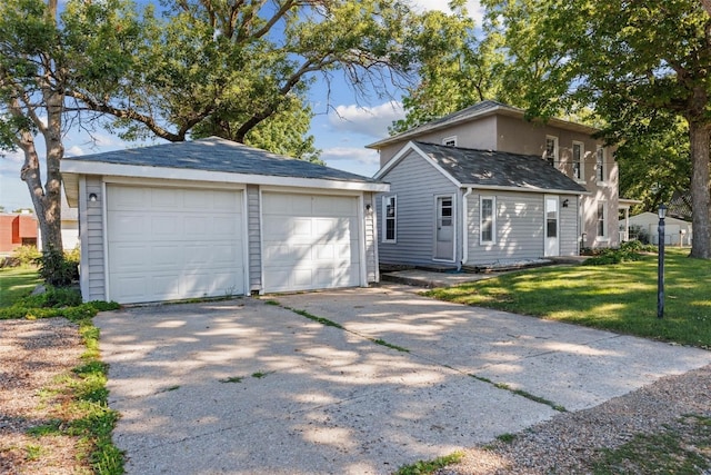 view of front of property with an outbuilding, a garage, and a front lawn