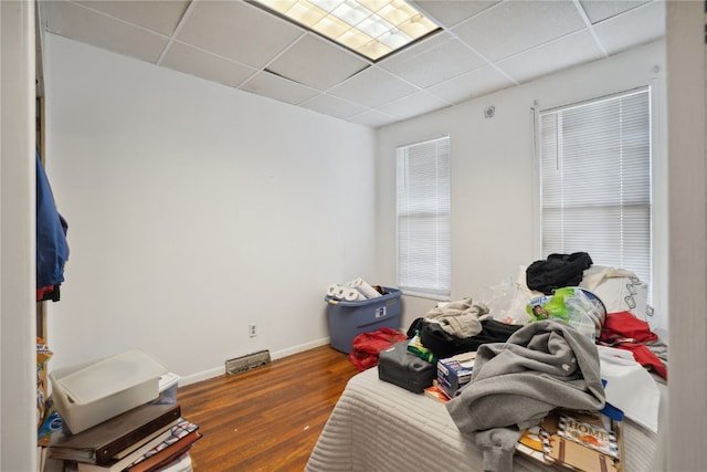 miscellaneous room with dark wood-type flooring and a drop ceiling