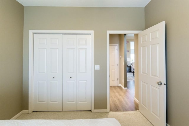 unfurnished bedroom with light colored carpet and a closet