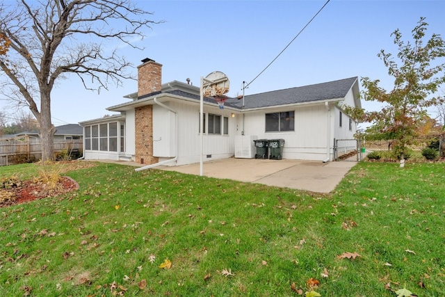 back of property with a sunroom, a patio area, and a yard