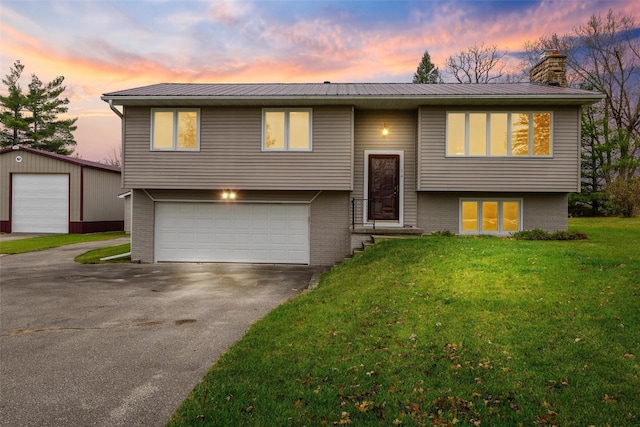 split foyer home featuring a lawn and a garage