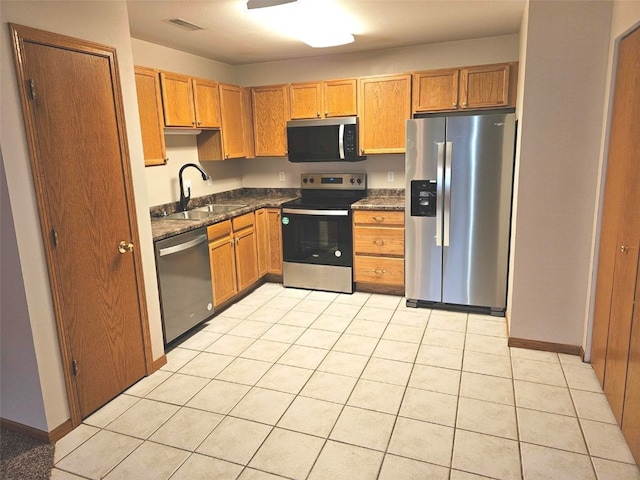 kitchen with sink, light tile patterned floors, and appliances with stainless steel finishes