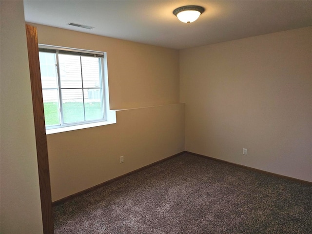 unfurnished room featuring dark colored carpet