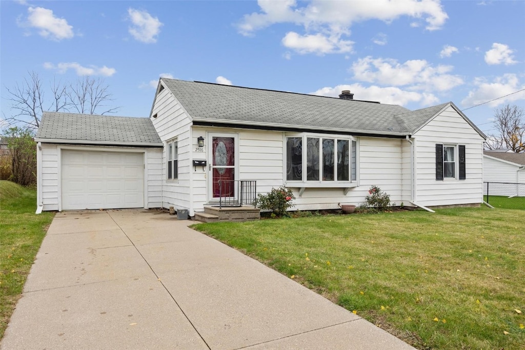 ranch-style home with a garage and a front lawn