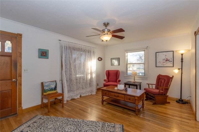 living area with ceiling fan, light wood-type flooring, and ornamental molding