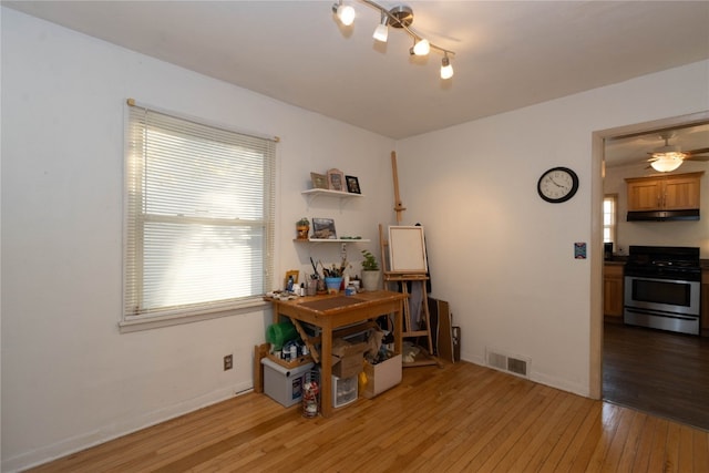 home office featuring ceiling fan and light hardwood / wood-style flooring