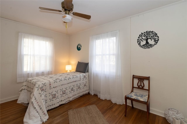 bedroom featuring dark hardwood / wood-style floors, multiple windows, and ceiling fan