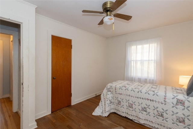 bedroom with ceiling fan, dark wood-type flooring, and ornamental molding