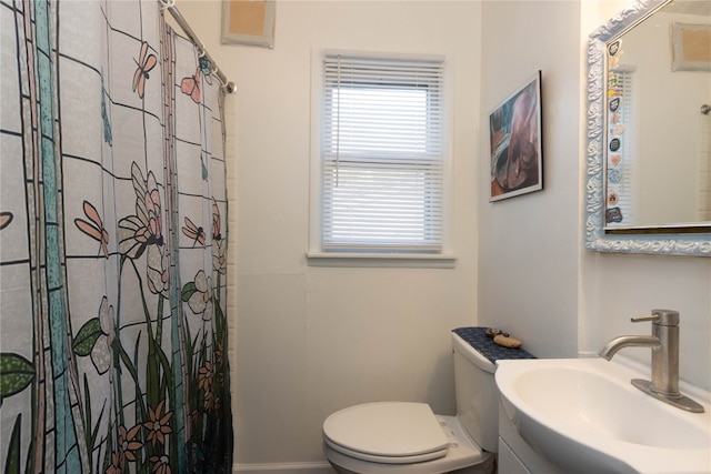 bathroom with toilet, sink, and walk in shower