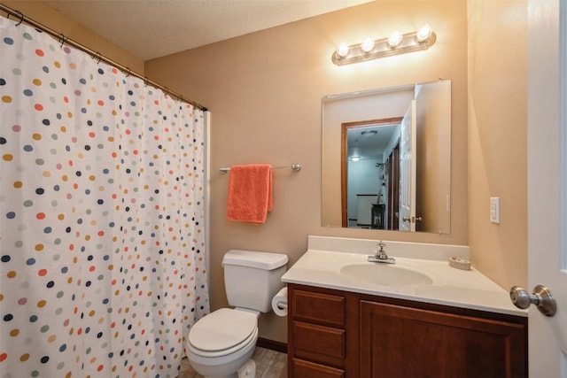 bathroom with a shower with curtain, vanity, toilet, and a textured ceiling